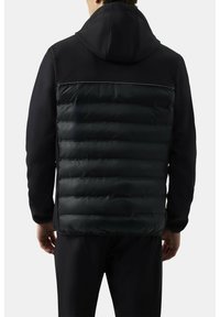 Czarna kurtka z pikowanym, puszystym tyłem, gładką górną częścią i przymocowanym kapturem. Smukły design o sportowym wyglądzie bez widocznych zapięć.