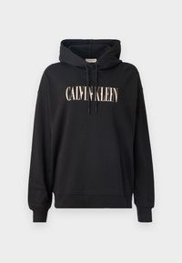 Črna kapuca s sprednjim žepom, kapuco s vrvico in logotipom "CALVIN KLEIN" v svetlo rožnati barvi. Narejena iz mehkega, teksturiranega materiala.