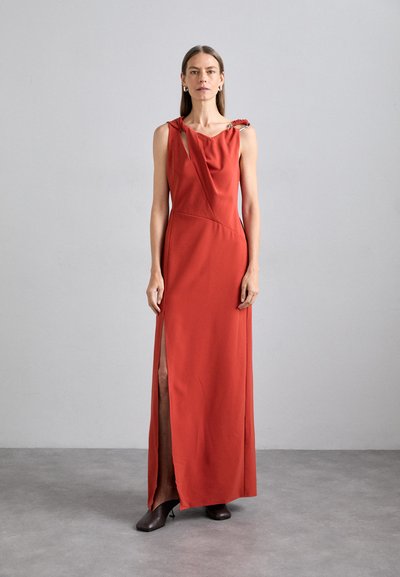 Robe rouge longue jusqu'au sol avec un décolleté asymétrique et une fente sur le côté. Fabriquée dans un tissu lisse, accentuée par un détail à motif sur l'épaule.