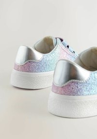 Glitzernde Turnschuhe mit einem Farbverlauf aus Blau, Pink und Lila, ausgestattet mit silbernen Akzenten an der Ferse und einer strukturierten weißen Sohle.