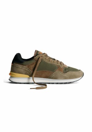 Sneaker scamosciato verde oliva e marrone con un retro nero, accenti beige e suola in gomma. Presenta lacci piatti e elementi di design sovrapposti.