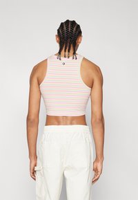 White cropped tank top with horizontal pastel stripes (pink, yellow, green). Features a round neckline and a small logo on the back.