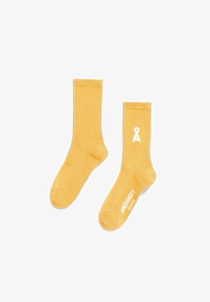 Chaussettes montantes côtelées jaunes en mélange de coton, avec logo blanc et détails de texte, texture douce et coupe standard.