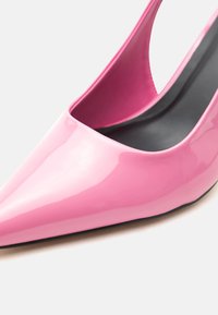 Γυαλιστερό ροζ αιχμηρό παπούτσι με λουράκι πίσω και ψηλό τακούνι με μαύρη εσωτερική σόλα σε λευκό φόντο, δείχνει λεπτομέρειες από μπροστά και από το πλάι.