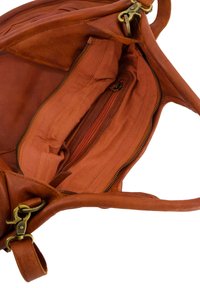 Braune Ledertasche mit offenem Innenraum, der ein strukturiertes Futter, zwei Reißverschlussfächer und robustes Tragewerk zeigt.