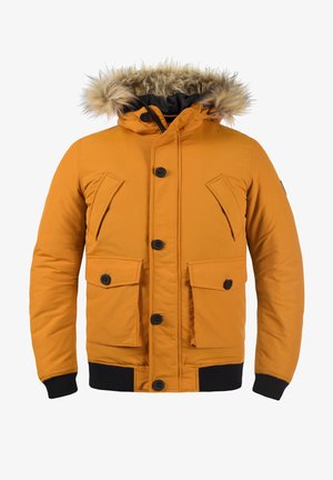 Manteau rembourré orange avec une capuche en fourrure, boutons noirs, deux poches avant, manches élastiques et ourlet côtelé. Finition en tissu lisse et mat.