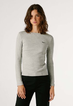 T-shirt ajusté à manches longues gris en texture côtelée. Empiècement d'un petit logo noir sur la poitrine gauche. Encolure ronde simple et ourlet droit.
