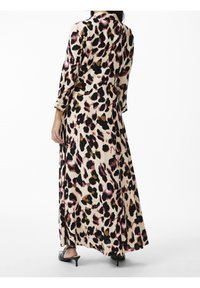 Abito lungo e fluido con uno sfondo beige e una stampa leopardata multicolore in rosa, nero e oro. Presenta maniche a tre quarti e una vestibilità rilassata.