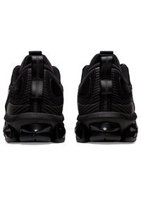 Černé sportovní boty s texturovaným mesh svrškem, vzorovanými detaily a lesklým podpatkem. Disponují viditelným systémem GEL odpružení v podrážce.