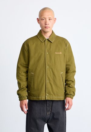 Olivengroene jas met kraag, drukknoopsluiting, elastische manchetten en een Timberland-logo. Gemaakt van stevige stof met contrasterende stiksels.