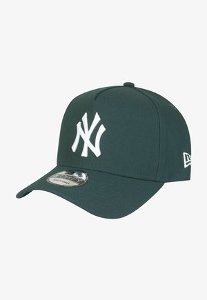 Green baseball cap with a white embroidered "NY" logo on the front, featuring a curved visor and a circular sticker on the brim.