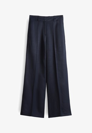 Weit geschnittene Hose aus dunkelblauem Stoff mit glatter Textur, ausgestattet mit einem vorderen Falz, Gürtelschlaufen und einem maßgeschneiderten Bund.