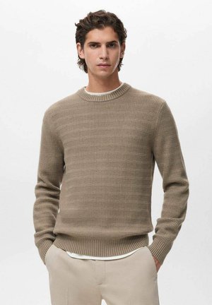Suéter de punto acanalado beige con cuello redondo y mangas largas, que presenta un patrón texturizado y puños y dobladillo acanalados ajustados.