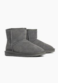 Grå mocka ankelstövlar med en slät yta, rund tå och en platt gummisula med mindre sömmar och utan utmärkande detaljer.