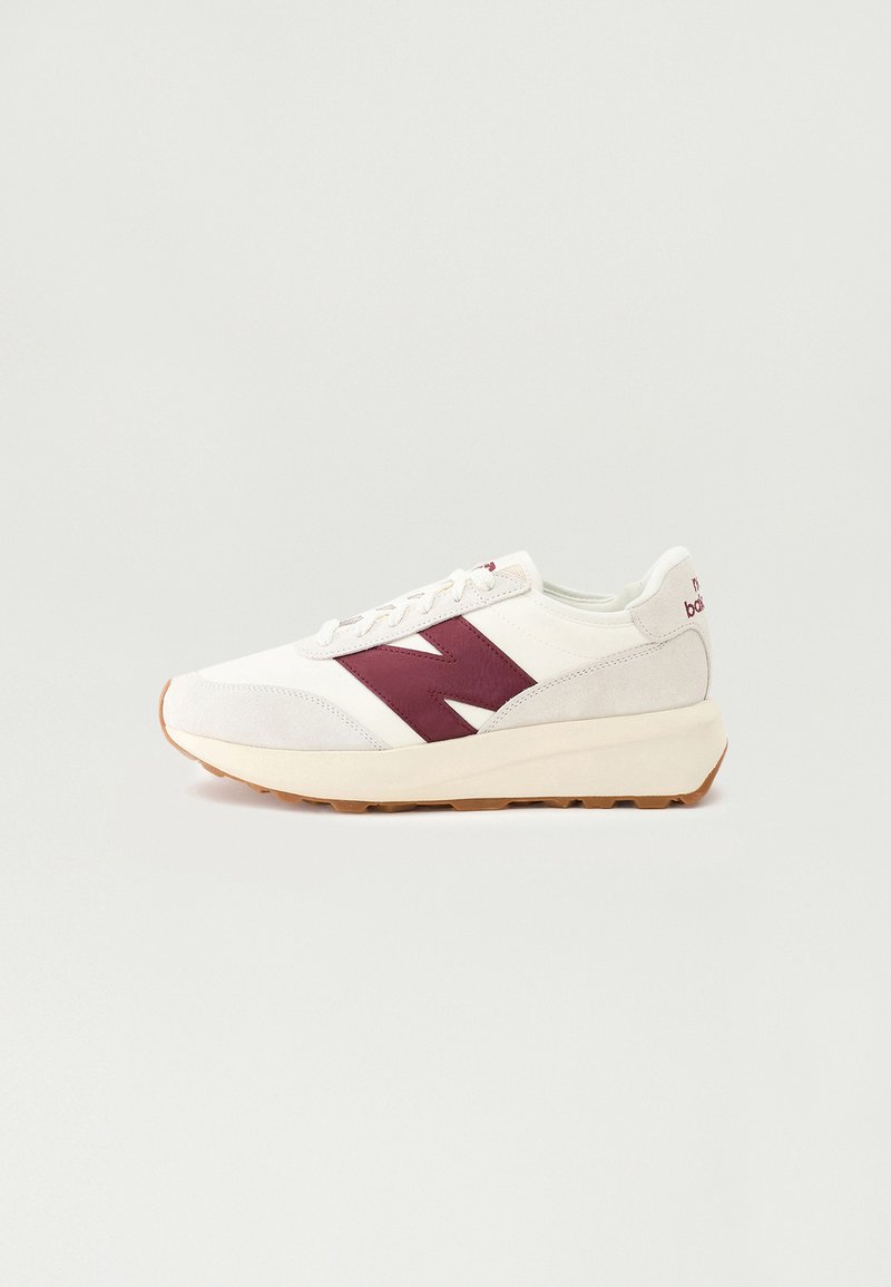 Fehér sneaker bordó velúr részletekkel, sima szövet felsőrésszel, kerek orral, fűzős előlappal és világosbarna gumitalppal.