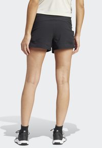 Pantalones cortos deportivos negros hechos de tejido elástico, con una cintura de altura media, una textura suave y un corte relajado para mayor comodidad.