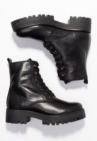 Černé kožené kotníkové boty s robustní, texturovanou podrážkou, šněrovacím designem a kontrastními kovovými detaily. Hladký povrch s odolným vzhledem.