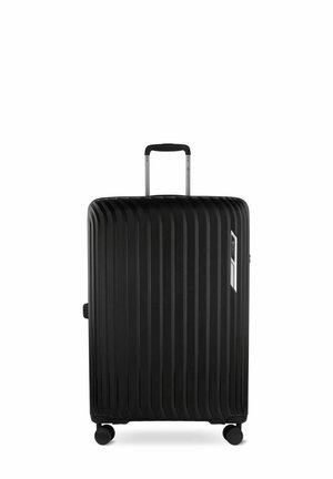 Valise rigide noire avec un design à rainures verticales, poignée rétractable, quatre roues et fermoir latéral. Texture lisse et apparence élégante.