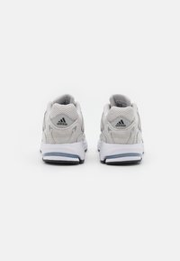 Bele atletske čevlje z mrežastim in semiš materialom, s podplatom za udobje in hrbtnim logotipom Adidas, zasnovani za udobje in podporo.