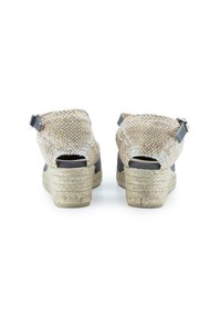 Sandalias de cuña con parte superior de yute beige trenzado, paneles laterales gris oscuro y suela de yute estilo espadrille. Parte trasera abierta con correa en el tobillo para mayor sujeción.