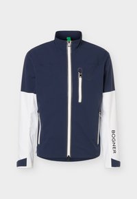 Veste marine et blanche avec fermeture éclair intégrale à l’avant, fermeture éclair de la poche poitrine, deux poches latérales, col montant, et texte « BOGNER » sur la manche droite.