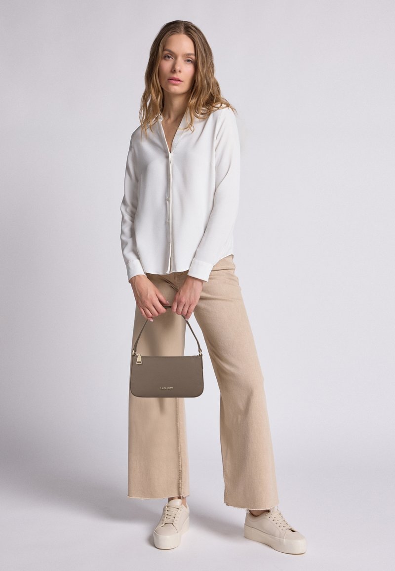 Camicia bianca con bottoni, pantaloni beige a gamba larga, sneakers color crema. Borsa marrone con texture e una piccola tracolla. Design semplice, palette di colori neutri.