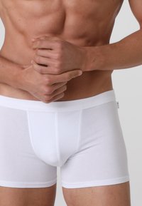 Boxer da uomo in cotone bianco con vestibilità aderente. Dotati di una morbida fascia elastica in vita e senza motivi o accenti visibili.
