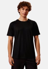 Sort crew-neck atletisk t-shirt, korte ærmer, ribbet tekstur, reflekterende accenter på skuldrene, tætsiddende design.