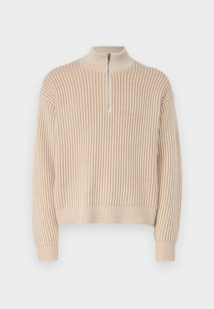 Pull en tricot beige à côtes avec un col montant et un devant court zippé. Présente des manches longues et une coupe décontractée. Motif tricoté texturé sur l'ensemble.