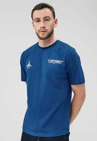 T-shirt in cotone blu con collo rotondo, maniche corte e logo ricamato "Top Gun" con grafica di aereo sul petto.