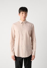 Hellrosa langärmliges Hemd mit Knopfleiste, das ein dezentes Streifenmuster mit kreisförmigen Designs aufweist. Klassischer Kragen und gerader Saum.