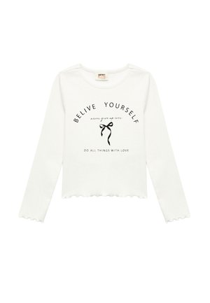 T-shirt blanc à manches longues avec un ourlet festonné. Présente un texte en noir : "CROIS EN TOI" et un graphique de nœud. Tissu en coton doux, coupe décontractée.