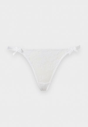 Biele čipkované tangá s kvetinovou výšivkou a malými stuhovými mašličkami na oboch stranách na jednofarebnom pozadí.