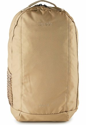 Zaino Beige Haglöfs Skuta 15 con scomparto principale con cerniera e tasca laterale in rete, progettato per l'uso all'aperto.