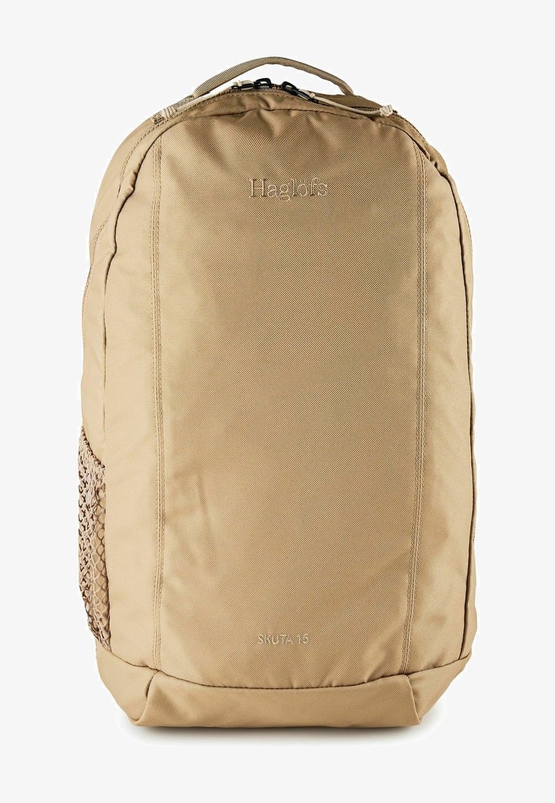Sac à dos beige Haglöfs Skuta 15 avec compartiment principal zippé et poche latérale en filet, conçu pour une utilisation en extérieur.