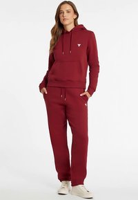 Maroon hoodie with drawstrings and front pocket, paired with matching joggers. Both made of soft fabric with a relaxed fit.