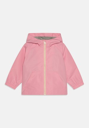 Giacca a pioggia rosa con cappuccio, zip frontale, polsini elasticizzati e due tasche anteriori. Fodera grigia visibile all'interno del cappuccio.