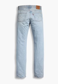 Jeans de mezclilla azul claro con un diseño de pierna recta, que cuentan con dos bolsillos traseros, costuras sutiles y un parche de cuero marrón en la cinturilla.