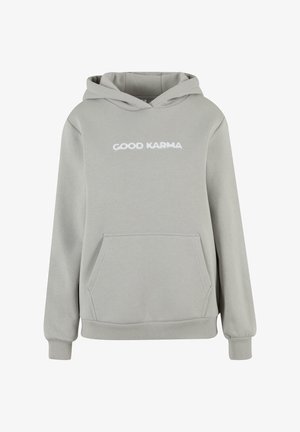 Šviesiai pilkas džemperis su priekiniais kengūros kišenėmis, raštuotais rankovių kraštais ir hemu. Ant džemperio išsiuvinėtas baltais raškais tekstas "GERA KARMA".