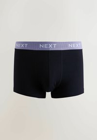Boxers noirs en tissu doux avec une ceinture élastique violet clair portant la marque "NEXT" en texte blanc.
