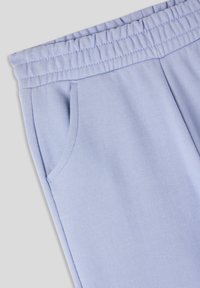Pantaloni jogger azzurro chiaro realizzati in tessuto morbido, con vita elastica, tasche laterali e una texture liscia.