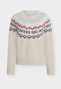 Beež kudumisetisega kampsun, millel on pikad varrukad. Omab värvilist mustrit sinise, punase ja musta kombinatsioonis, millel on kaelus ümber kirjas "APRÈS SKI".