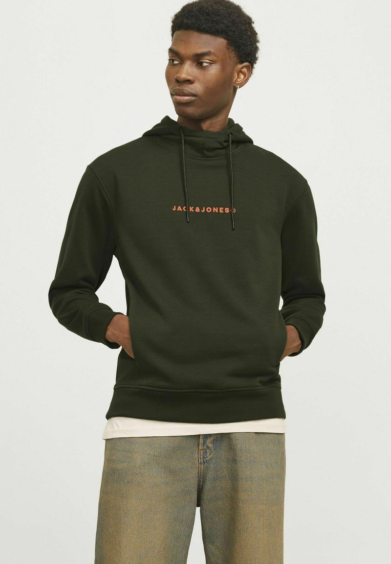 Mørkegrøn hoodie med en forlommer, der har et orange "JACK & JONES" logo. Den har hætte med snore og ribbede manchetter. Båret over en lys t-shirt.