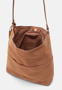 Borsa a spalla in suede marrone con un design morbido, dotata di una tasca foderata e una chiusura a scatto in ottone. Texture morbida e hardware minimale.