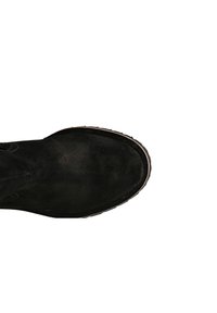 Botín de ante negro hasta el tobillo con puntera redondeada, superficie texturizada y costuras marrones en contraste a lo largo de la suela. Diseño minimalista, sin adornos.