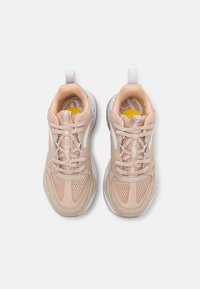 Chaussures de sport beiges avec panneaux en maille, superpositions texturées, design à lacets et accents blancs. Dotées d'un col rembourré et d'un logo sur la languette.