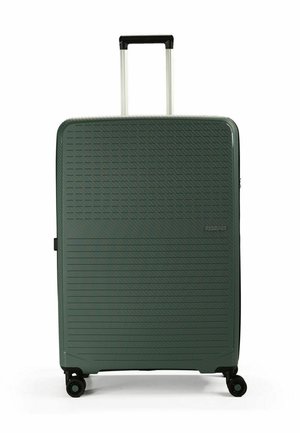 Valigia rigida verde con linee diagonali e orizzontali testurizzate, manico telescopico e quattro ruote per una facile mobilità.