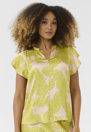 Blusa a maniche corte in tessuto rosa chiaro con grande stampa di foglie di monstera verdi, caratterizzata da una vestibilità rilassata e un design con colletto a scollo.