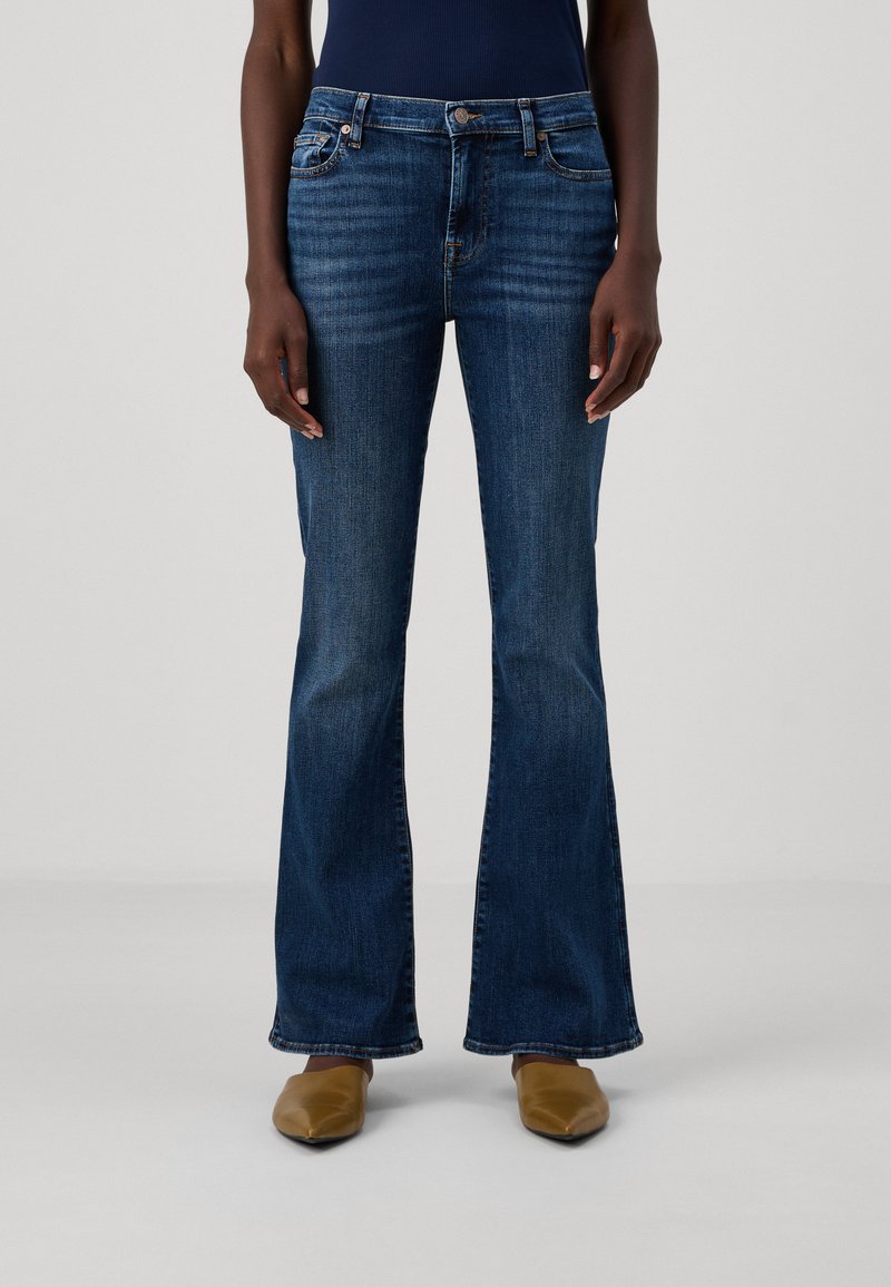Brettede blå denimjeans med midjehøyde, med subtil falming, fem lommer og kontrastsøm. Detaljer med kobberhardware.