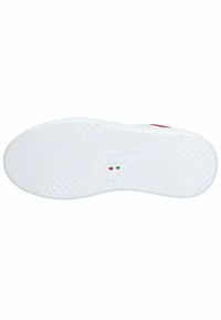 Suola di sneaker bianca con un motivo testurizzato, caratterizzata da elementi di presa triangolari e circolari, etichettata "Fatto in Italia." Superficie complessivamente liscia.